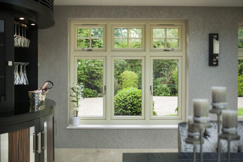 Cream-coloured casement window with multiple panes, looking out onto a green garden.